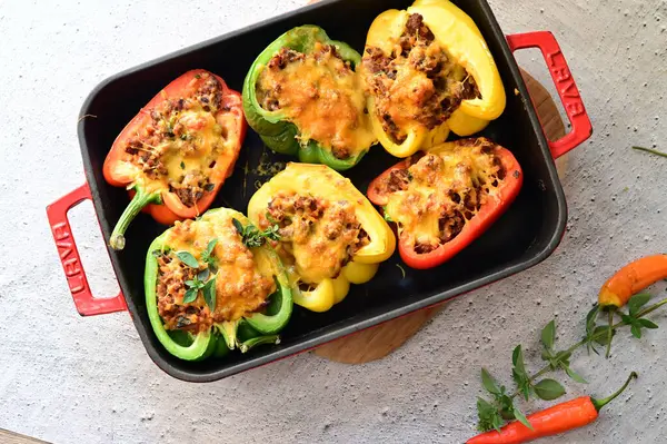 Doldurulmuş biber, kıyma, sebze ve et, ahşap bir masada demir tava.