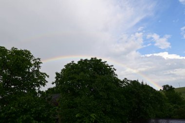 Gökkuşağı ve bulutlu güzel bir manzara.
