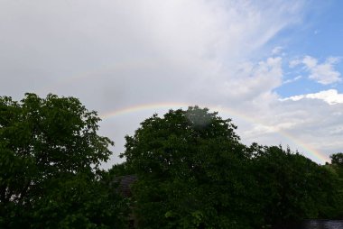 Amsterdam 'da bir şehir caddesinde gökkuşağı ve bulutlar