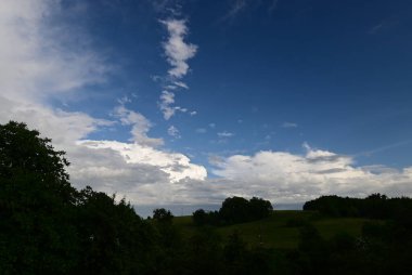 Bulutları ve mavi gökyüzü olan güzel bir manzara.