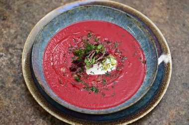 Kremalı pancar çorbası ve beyaz tabakta otlar.