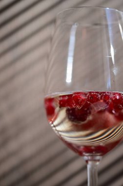 Ahşap bir arka planda kırmızı böğürtlenli şarap kadehi Neşeli Doğal Elementlerin ve Kırsal Zarafetin Yakın Çekimi