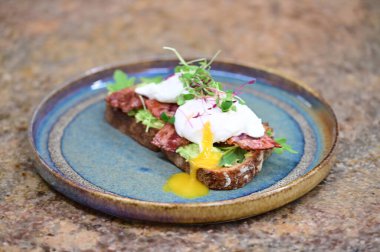 Haşlanmış yumurta, pastırma ve krema soslu tost. Lezzetli kahvaltı