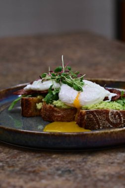 Kavrulmuş yumurtalı tost, haşlanmış yumurta, avokado ve otlar. sağlıklı kahvaltı.