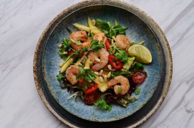 Taze sebzeli ve karidesli baharatlı Tayland salatası. Çok güzel tabaklar ve canlı bir restoran ortamında servis ediliyor. Biber, bitki, limon ve deniz ürünlerini birleştiren renkli, egzotik bir yemek otantik Tayland mutfağı ve sağlıklı beslenmenin mükemmel bir örneğidir..