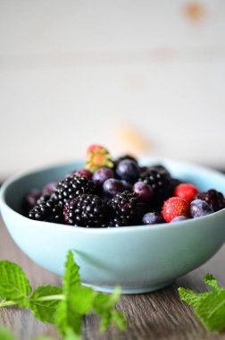 Masadaki nane yapraklı taze meyveler.