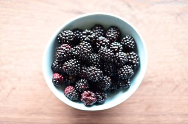 Taze böğürtlenler beyaz masada, üst tarafta.