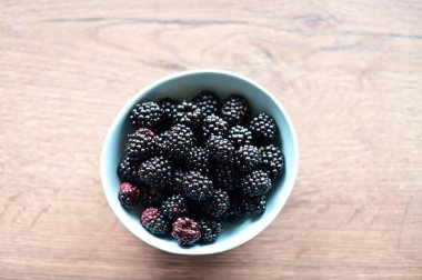 Tabakta böğürtlen ve ahşap arka planda