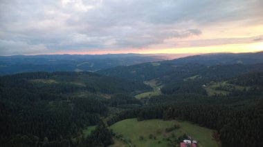 Orman ve dağların üzerinde çarpıcı bir günbatımının hava aracı görüntüsü Beskydy bölgesindeki Çek ve Slovakya manzaralarını yakalıyor..