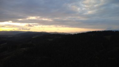 Orman ve dağların üzerinde çarpıcı bir günbatımının hava aracı görüntüsü Beskydy bölgesindeki Çek ve Slovakya manzaralarını yakalıyor..