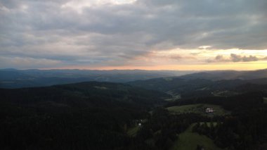 Orman ve dağların üzerinde çarpıcı bir günbatımının hava aracı görüntüsü Beskydy bölgesindeki Çek ve Slovakya manzaralarını yakalıyor..