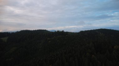 Orman ve dağların üzerinde çarpıcı bir günbatımının hava aracı görüntüsü Beskydy bölgesindeki Çek ve Slovakya manzaralarını yakalıyor..