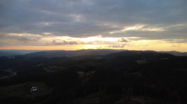 Orman ve dağların üzerinde çarpıcı bir günbatımının hava aracı görüntüsü Beskydy bölgesindeki Çek ve Slovakya manzaralarını yakalıyor..