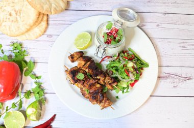 fried chicken with vegetables and sauce on white plate