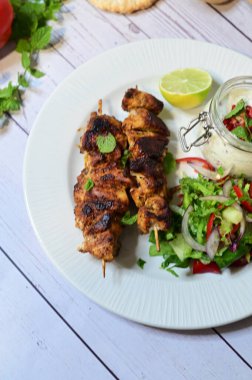 grilled meat with vegetables and spices on a table.