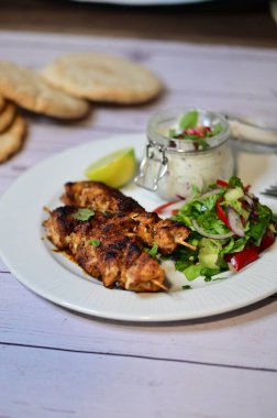 grilled chicken with vegetables and sauce, on a wooden background