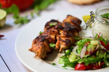 grilled chicken wings with vegetables on a wooden board
