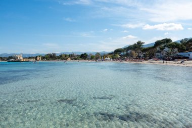 Mondello Körfezi ve sahilinde yaz güneşinde turistler ve şeffaf mavi deniz. Sicilya 'da tatil yeri, Palermo plajı. İtalya. İtalyan denizi. Akdeniz.