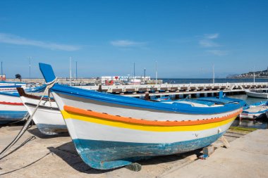 Güneşli bir yaz gününde Mondello 'nun küçük limanına demirlemiş geleneksel renkli balıkçı tekneleri. Akdeniz limanında küçük tekneler. Sicilya, Mondello, Palermo 'da ünlü bir yaz tatili yeri.
