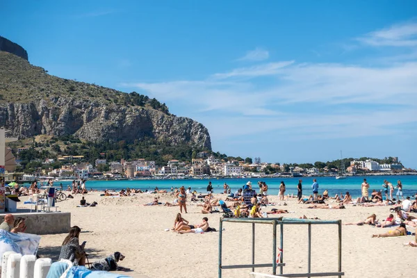 Turkuaz şeffaf mavi deniz ve güneşli gökyüzünde turistlerin olduğu Mondello kumsalı. Sicilya, Palermo, İtalya 'da tatil. İtalyan denizi. Akdeniz 'e