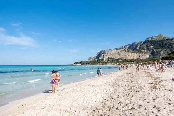 Turkuaz şeffaf mavi deniz ve güneşli gökyüzünde turistlerin olduğu Mondello kumsalı. Sicilya, Palermo, İtalya 'da tatil. İtalyan denizi. Akdeniz 'e