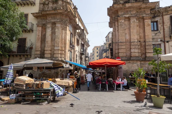 Güney İtalya 'nın geleneksel sokak pazarı. Palermo 'nun ünlü Capo pazarında tezgahlar ve masalarda oturan insanlar var. Kalabalık pazar. Sicilya, Palermo, İtalya