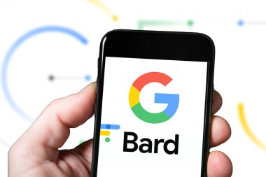 Gözlük ve Yapay Zeka araçlı bir akıllı telefonun ekranı, yapay zeka. Google 'dan Bard the AI Chatbot kullanan bir adam. Google Bard web sitesi ve logosu