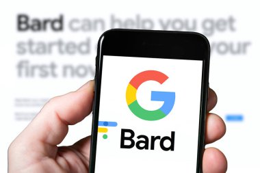Goggle Bard Yapay Zeka Chatbot aracı, yapay zeka. Akıllı telefonlu bir adam Bard Ai web sitesini kullanıyor. Bard AI ile mobil ekran