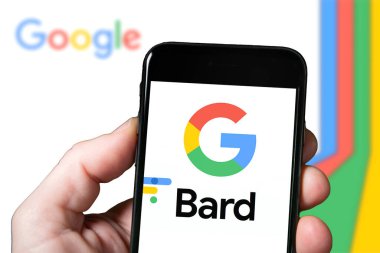 Gözlük ve Yapay Zeka araçlı bir akıllı telefonun ekranı, yapay zeka. Google 'dan Bard the AI Chatbot kullanan bir adam. Google Bard web sitesi ve logosu