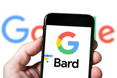 Gözlük ve Yapay Zeka araçlı bir akıllı telefonun ekranı, yapay zeka. Google 'dan Bard the AI Chatbot kullanan bir adam. Google Bard web sitesi ve logosu