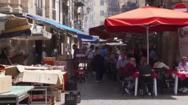 İtalya 'da bir sokak pazarındaki insanlar. Palermo 'daki ünlü ve turistik Capo pazarında tezgâhlar, tüccarlar ve turistler bir barın masalarında oturuyor. Güney İtalya pazarı. Palermo, İtalya 