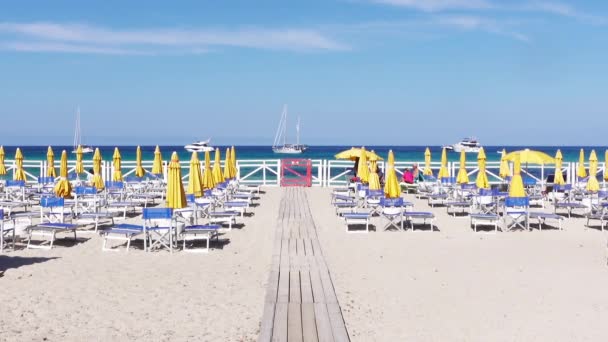Zandstrand Met Gekleurde Strandparasols Zomerzon Transparante Turquoise Blauwe Zee Met — Stockvideo