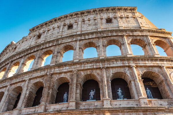 Italy, Rome, famous monument Coliseum (Colosseo) facade with blue sky.