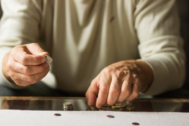 Kriz anında masanın üstünde bozuk para sayan kıdemli bir adam. Yaşlı adam Polonyalı paraları istifliyor ve para hesaplıyor. Yoksulluk, enflasyon ve finansal sorunlar kavramı. Avrupa 'da yüksek enflasyon.