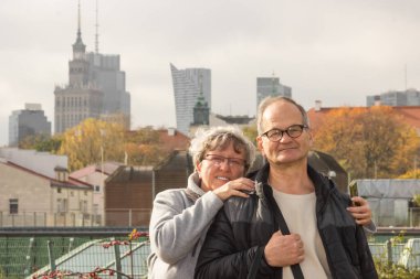 Varşova 'nın sonbahar caddesinde sarılıp yürüyen mutlu yaşlı çift. Gülümseyen yaşlılar Avrupa 'da seyahat eden gözlüklerle evleniyor. Aktif yaşlılar konsepti. Mutlu hafta sonları.. 