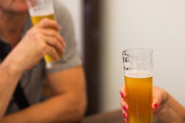 Czech bira fabrikasında kadınların elinde köpüklü light bira bardağı var. Yaşlı kadın kocasıyla barda bira içiyor. Hafta sonu aile ve arkadaşlarla toplantı. Oktoberfest kavramı.