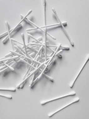 A group of white cotton swabs for cleaning the ears. Daily ear hygiene concept. Top view. Cosmetics background.