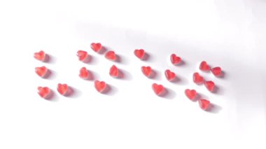 Womans hand added a dot after the word love. Romantic message from jelly candies in hearts form. Top view. Valentines Day concept. High quality FullHD footage