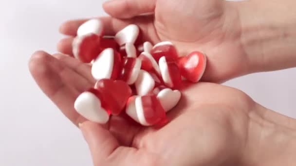 女性の手は 赤と白のハート型のゼリーキャンディーの一握りをソートします バレンタインデーとロマンチックなコンセプト 高品質のフルHd映像 — ストック動画