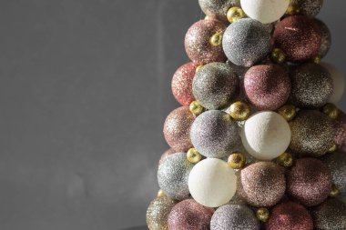 Pembe, beyaz ve altın renkli pırıltılı mücevherlerden elde edilen el yapımı katlanabilir Noel ağacı. Beyaz arka plan. Kış yaratıcılığı ve Noel zanaatı kavramı. Modaya uygun bir Noel ağacı. DIY kavramı.