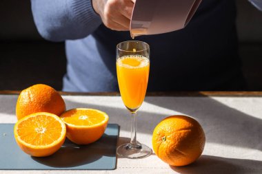 Son sınıf öğrencisi sıkılmış portakal suyunu manuel plastik meyve sıkacağından cama döküyor. Yaşlı adam kahvaltı için ev yapımı meyve suyu yapıyor. Sağlıklı yaşam tarzı kavramı. Diyet ve vitamin kokteyli ile oruç tutma günü.