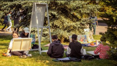 Almaty, Kazakistan - 18 Eylül 2022. Genç sanatçılar şehir parkında açık havada resim yaparlar.