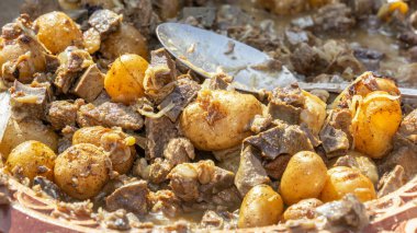 Geleneksel Asya yemeği kaurdak kızarmış et, ciğer, böbrek, ciğer, patates, ahşap tabakta soğan. Yakın plan.