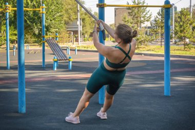 Spor sahasında egzersiz yaparken spor ipinde barfiks çeken çekici beyaz kadın. Sağlıklı yaşam tarzı