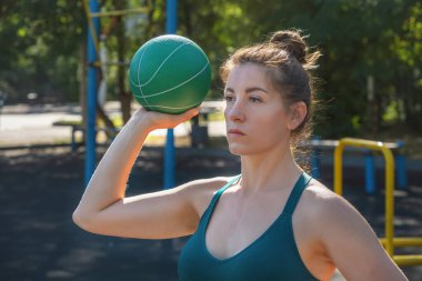 Beyaz bir kadın sokak sporları alanında lastik genişleticiyle egzersiz yapıyor. Yakın plan.