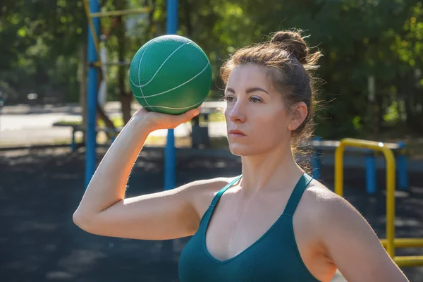 Beyaz bir kadın sokak sporları alanında lastik genişleticiyle egzersiz yapıyor. Yakın plan.