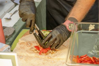 Aşçı shawarma ekmeğine sebze koyar. sokak yemekleri