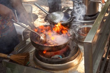 Yanan bir tencerede et ve sebzelerden Asya yemeği pişirmek. Fast food