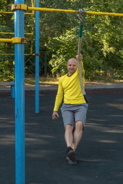 Avrupalı bir adam spor sahasında spor ipiyle egzersiz yapıyor. Sağlıklı yaşam tarzı