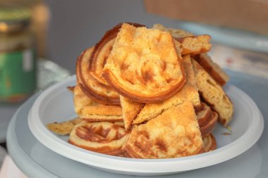 Sokak satıcıları için beyaz plastik tabakta taze pişmiş ev yapımı Belçika waffle 'ları. Yakın plan.